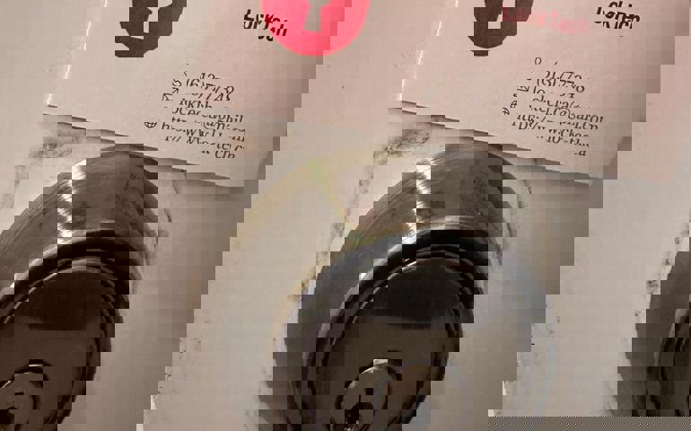 LockTech car and home locksmith business card above a new deadbolt lock on residential door.